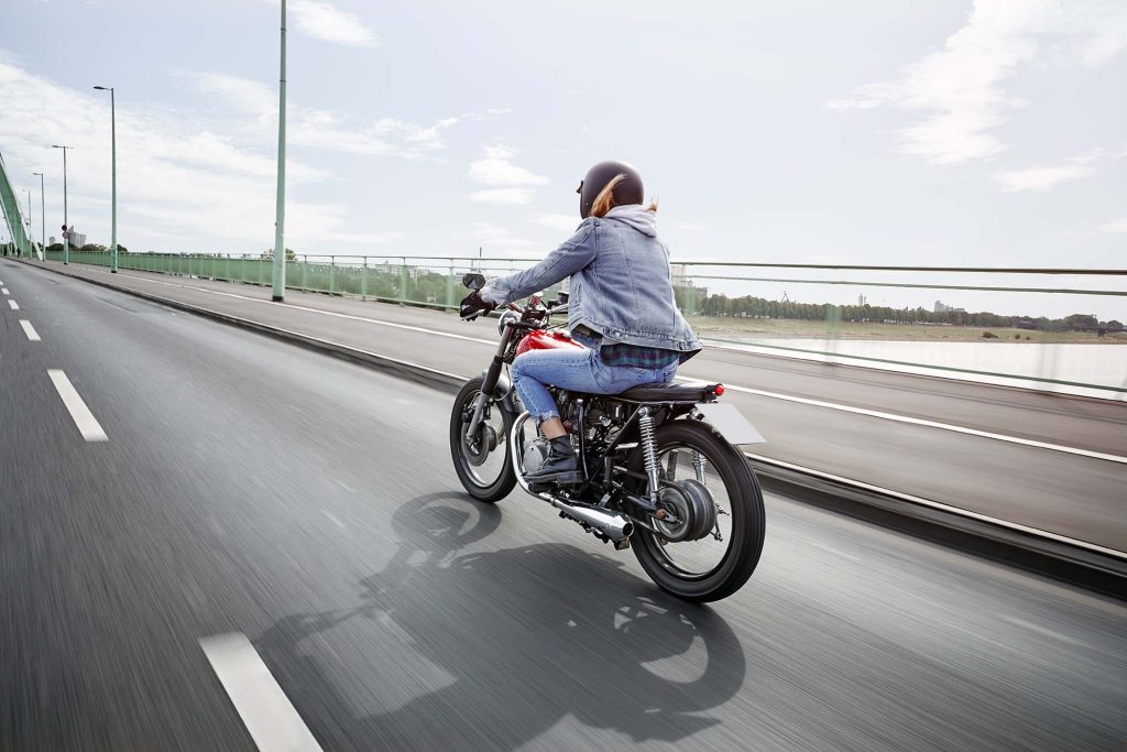 young-woman-riding-motorcycle-on-bridge-S8NLHXX-1024x683